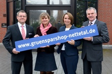 Die Geschäftsleitung und Mitarbeiterinnen des Marketings halten einen Banner mit der Adresse des Grünspar-Shops in der Hand