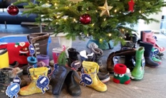 Stiefel stehen vor einem geschmückten Tannenbaum